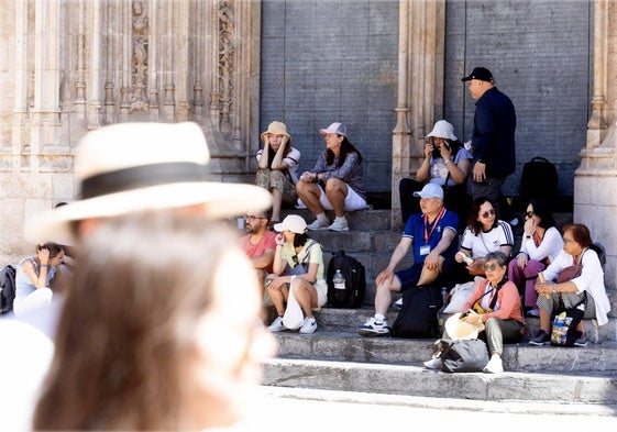 Un grupo de turistas descansa y come algo en los escalones de la Lonja, esta semana.
