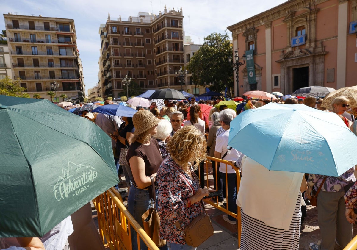 Público asistente al Besamanos del miércoles, refugiándose del sol con paraguas.