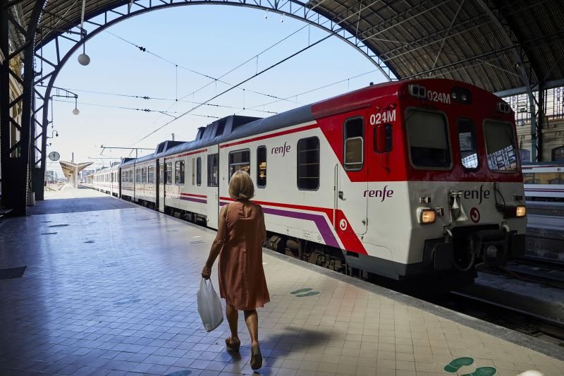 Una pasajera junto a un tren de Renfe.