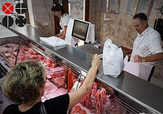 Una clienta recoge su compra en una carnicería de Carcaixent.