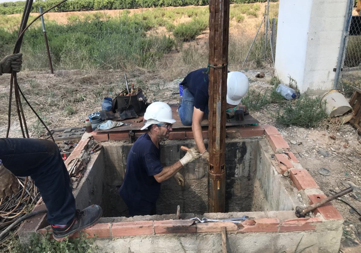 Reparación. Un equipo de especialistas extrae, con ayuda de una grúa, la tubería y la bomba de impulsión de un pozo de riego.