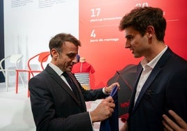 El presidente francés Emmanuel Macron recibe la camiseta antiahogamiento.