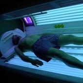 Un hombre se broncea en una cabina de rayos UVA.