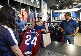 Una aficionada del Levante comprar una camiseta de Carlos Álvarez.