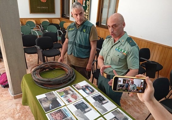 Dos de los investigadores de la Guardia Civil junto a un rollo de cable de cobre recuperado.
