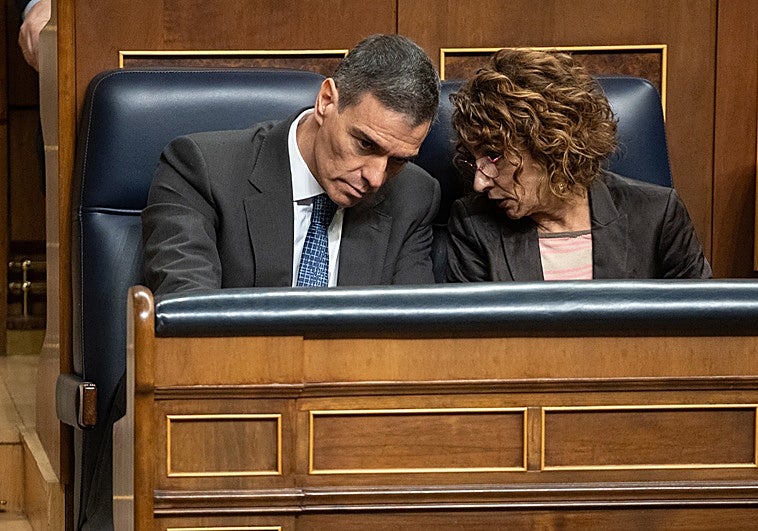 María Jesús Montero conversa con Pedro Sánchez en el Congreso.