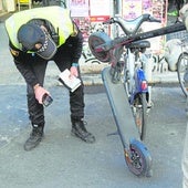 Un policía local inspecciona un patineta en una imagen de archivo.