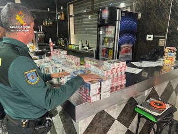 Un guardia civil, con el tabaco supuestamente robado intervenido en el bar.
