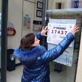 Una empleada de una administración de lotería coloca el cartel anunciador del premio. Imagen de archivo.