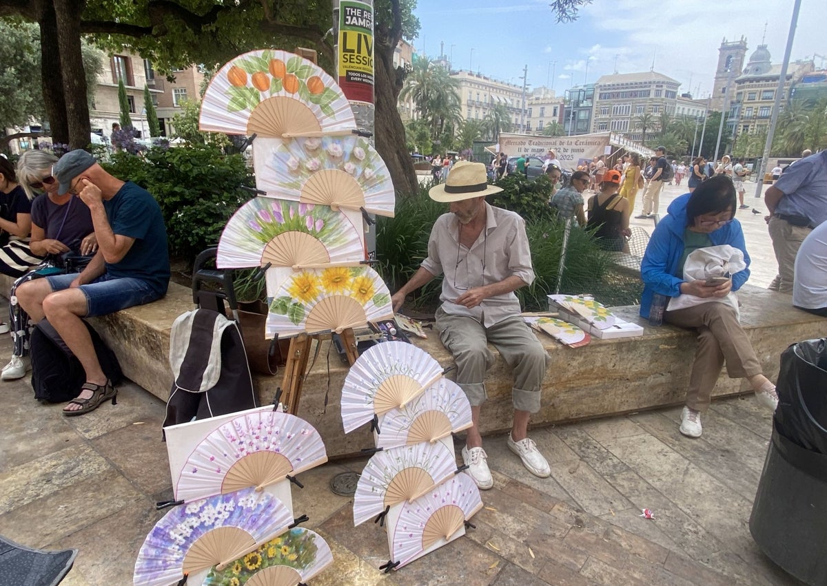 Imagen secundaria 1 - Las italianas Carlota y Matilde, con un ventilador portátil; Rafael José Pascual, vendiendo abanicos y zona refrescante de la plaza de la Reina.