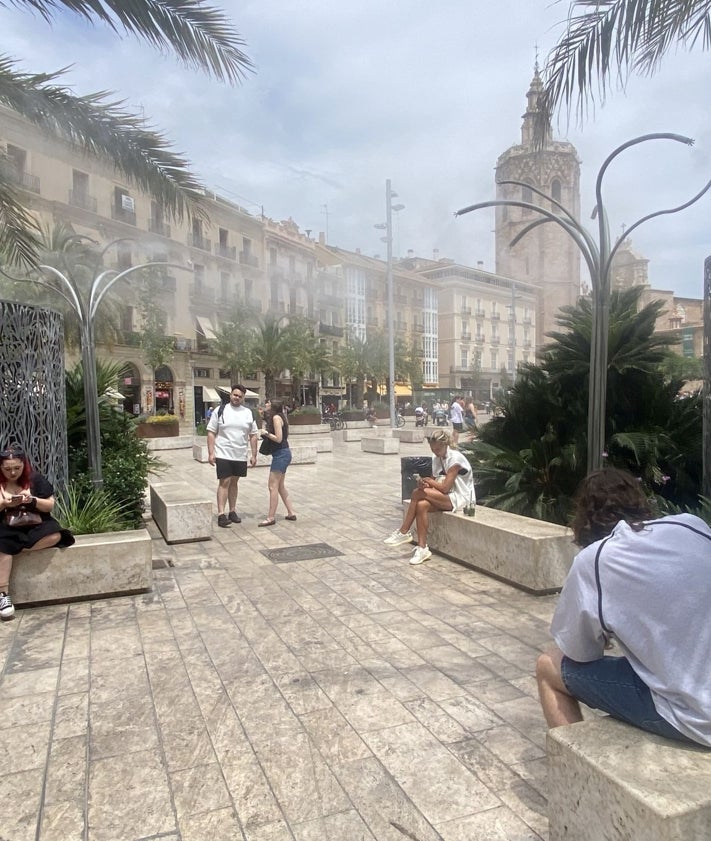 Imagen secundaria 2 - Las italianas Carlota y Matilde, con un ventilador portátil; Rafael José Pascual, vendiendo abanicos y zona refrescante de la plaza de la Reina.