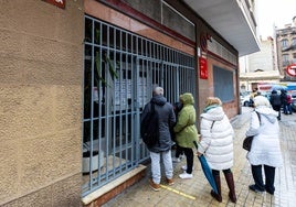 Varias personas ante un centro de salud cerrado en Valencia.