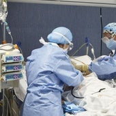 Dos sanitarios atienden a un paciente infeccioso.