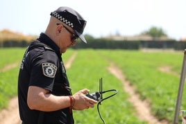 Un agente maneja el dron con el que se vigilan los campos.