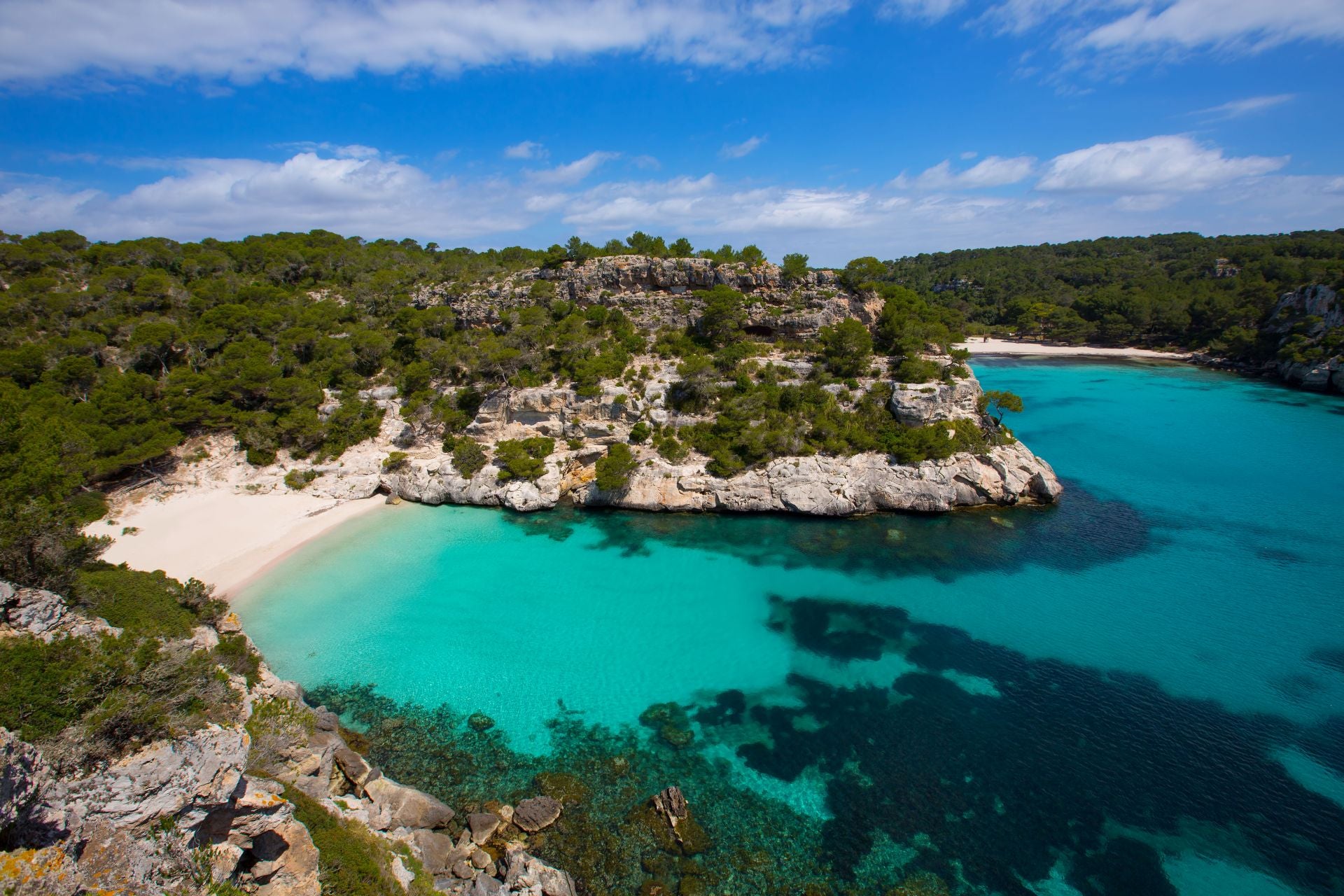 Cala Macarella, Menorca, Islas Baleares (España). Está a 14 kilómetros de Ciutadella y forma parte de Àrea Natural dEspecial Interès de la costa sur de Ciutadella. «Está considerada una de las playas más bellas de Menorca y es una de las más visitadas», indican. Protegida por el Plan Territorial Insular y por la Red Natura, «la icónica cala ofrece un paisaje espectacular: talud de arena, un agua cristalina y tranquila, una pendiente suave y una brisa marina. Este paisaje es típico del litoral meridional menorquín», destacan. «La costa gana altura, se vuelve agreste e inaccesible, excepto por la irrupción de mangas de mar, coincidentes con desembocaduras de escorrentías y barrancos, alumbrando bellas zonas de baño y excelentes refugios marítimos», añaden.