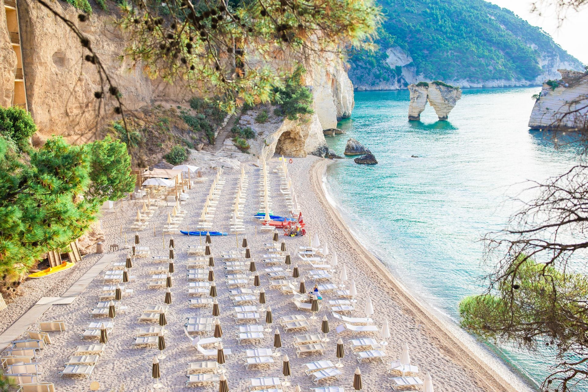 La bahía delle Zagare, Gargano, Puglia (Italia). La característica distintiva de esta playa, indican, son «un par de poderosos farallones de roca caliza esculpidos y modelados por el viento, son el emblema». Se trata de una de las localidades costeras «más exclusivas, célebres por su arena dorada mezclada con guijarros blancos y dividida en dos por un alto acantilado de piedra caliza». La playa está considera como una de las 10 más bonitas del mundo.