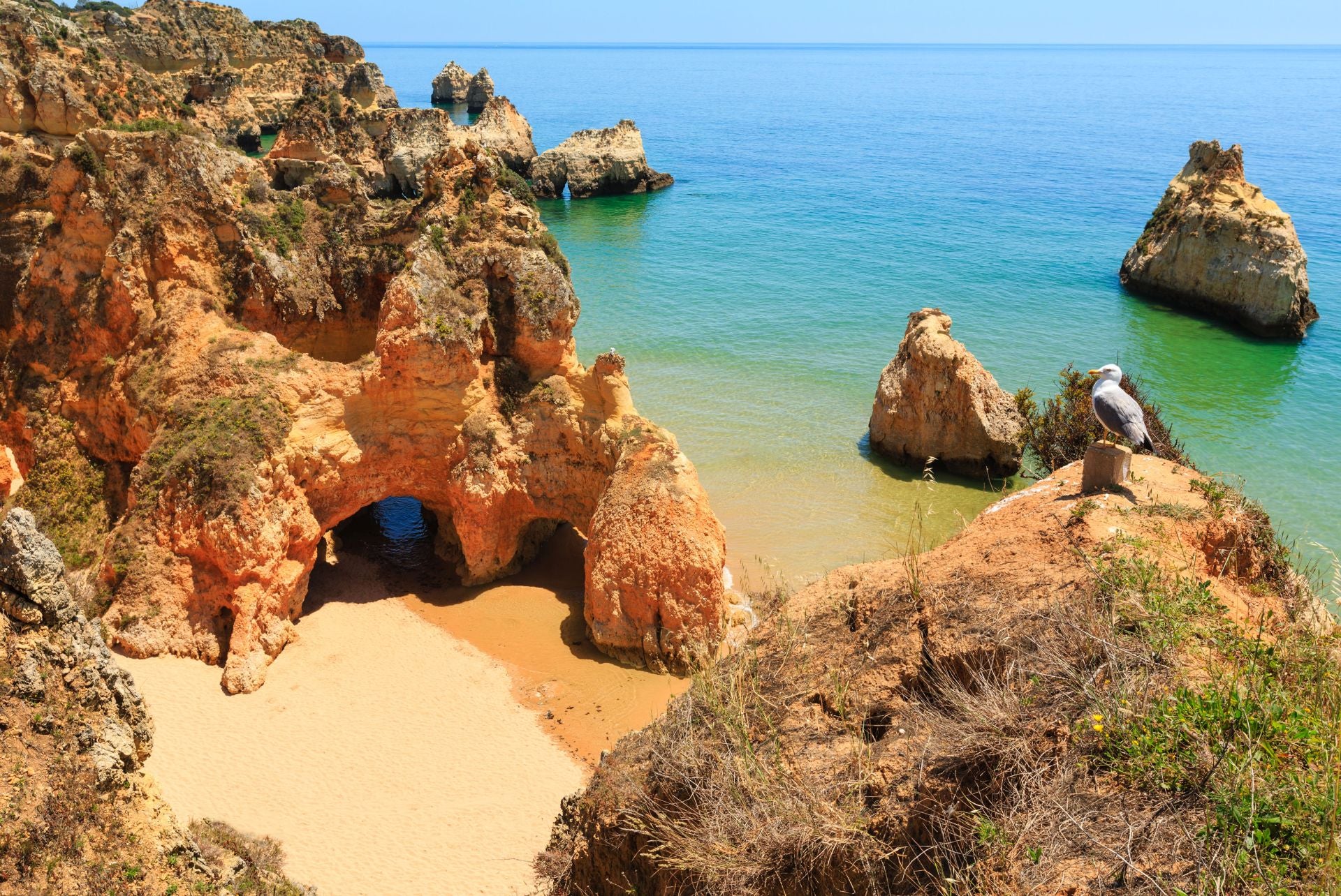 Praia dos Três Irmãos, Algarve (Portugal). Su nombre original es Playa Alvor Nascente. Lo más llamativo son sus tres formaciones rocosas en el lado Este, con altas rocas y acantilados, que se conocen como falesias. Al otro lado tiene dunas que se extienden un kilómetro. «En los meses de julio y agosto suele haber bastante gente, pero no tanto como en las playas más cercanas al centro de Portimão», indican. «El agua suele estar tranquila y por lo tanto es bastante segura para los niños», explican. Además, señalan que «para comer no es necesario ir muy lejos: hay restaurantes en la playa, especializados en ricos arroces y una gran variedad de mariscos y pescados asados con abundante guarnición, pero que también ofrecen otras opciones». Por último, aforman que «después de un día de playa, no hay nada mejor que disfrutar del atardecer y de una cena con vistas al mar y a las bellas puestas de sol».