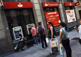 Usuarios del banco aguardan para sacar dinero de cajeros automáticos, en una imagen de archivo.