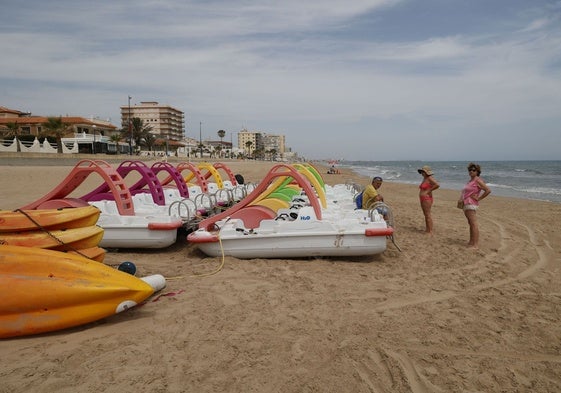Bañistas en la playa de Daimús a la espera de poder bañarse.