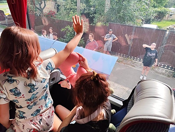 Los niños ucraniados, desde el autobús que les llevará a Valencia, se despiden de sus familias.