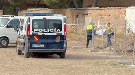 Dos empleados del retén fúnebre trasladan el cuerpo de la víctima.