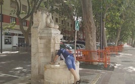 Un hombre se refresca en una fuente de Xàtiva.