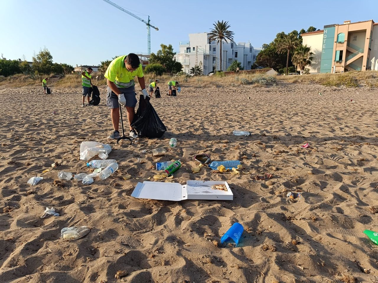 Los operarios del servicio de limpieza de playas retiran la basura de la noche de San Juan.