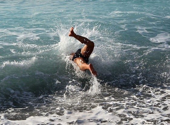 Un joven se baña en el mar.