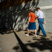 Dos jubilados pasean por una calle.
