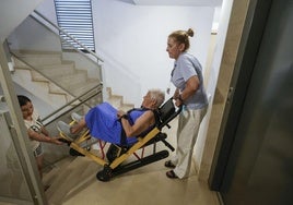 Anna (d) sostiene la silla oruga donde está sentada su madre Carmen.