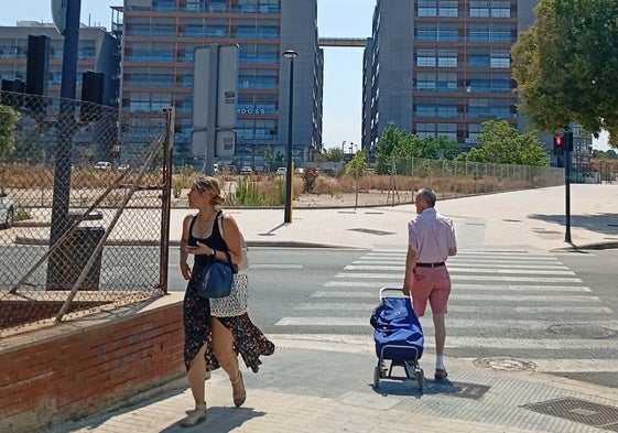 Una joven camina por la acera de la avenida Tres Cruces mientras habla por teléfono.
