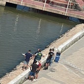 Un guardia civil y varios testigos junto al cadáver tapado con una sábana blanca.