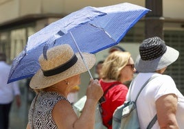 Unas mujeres se protegen del calor en Valencia.