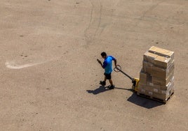 Un hombre transporta varias cajas en Valencia.
