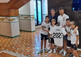 Corona y Raba, con los cuatro niños que protagonizaron la escena de jugar al fútbol en medio del barro por la dana.