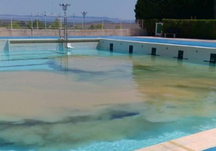 Piscina municipal con el barro salido de las tuberías.