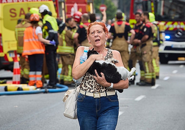 Una vecina tras reunirse con su gata rescatada por los bomberos.