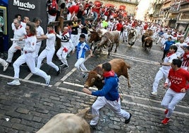 Corredores en el tercer encierro de San Fermín 2025.