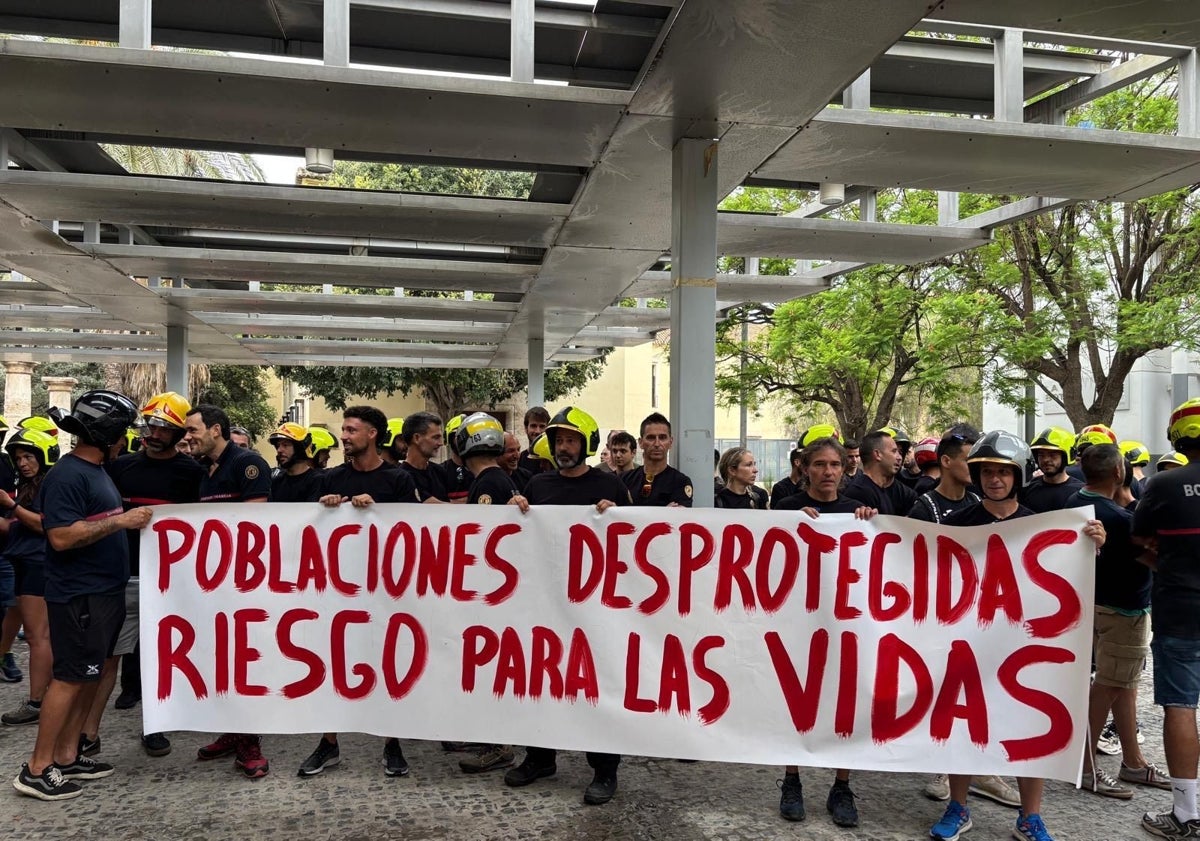 Imagen principal - Algunos de los carteles que los bomberos han traído a la protesta por la falta de personal y medios que sufren desde hace años.