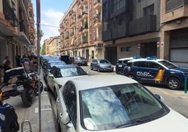 Un grupo de vecinos y policías comentan el suceso en la calle.
