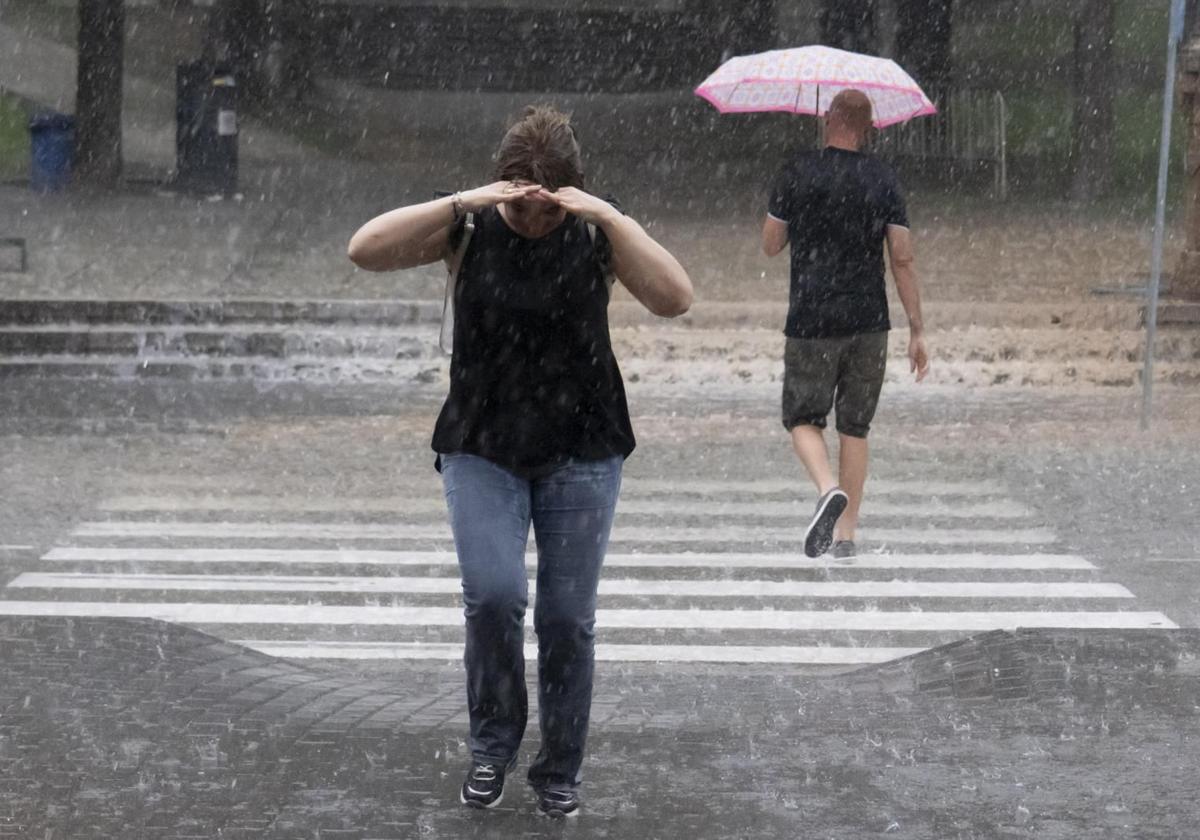 Dos personas se protegen de la lluvia en verano.