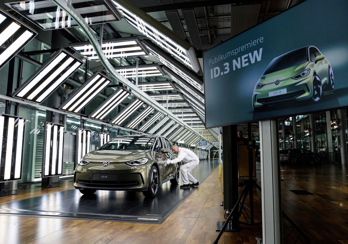 Un empleado de Volkswagen, junto al nuevo modelo eléctrico en la fábrica de Dresden.