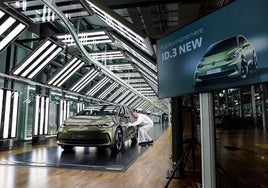 Un empleado de Volkswagen, junto al nuevo modelo eléctrico en la fábrica de Dresden.