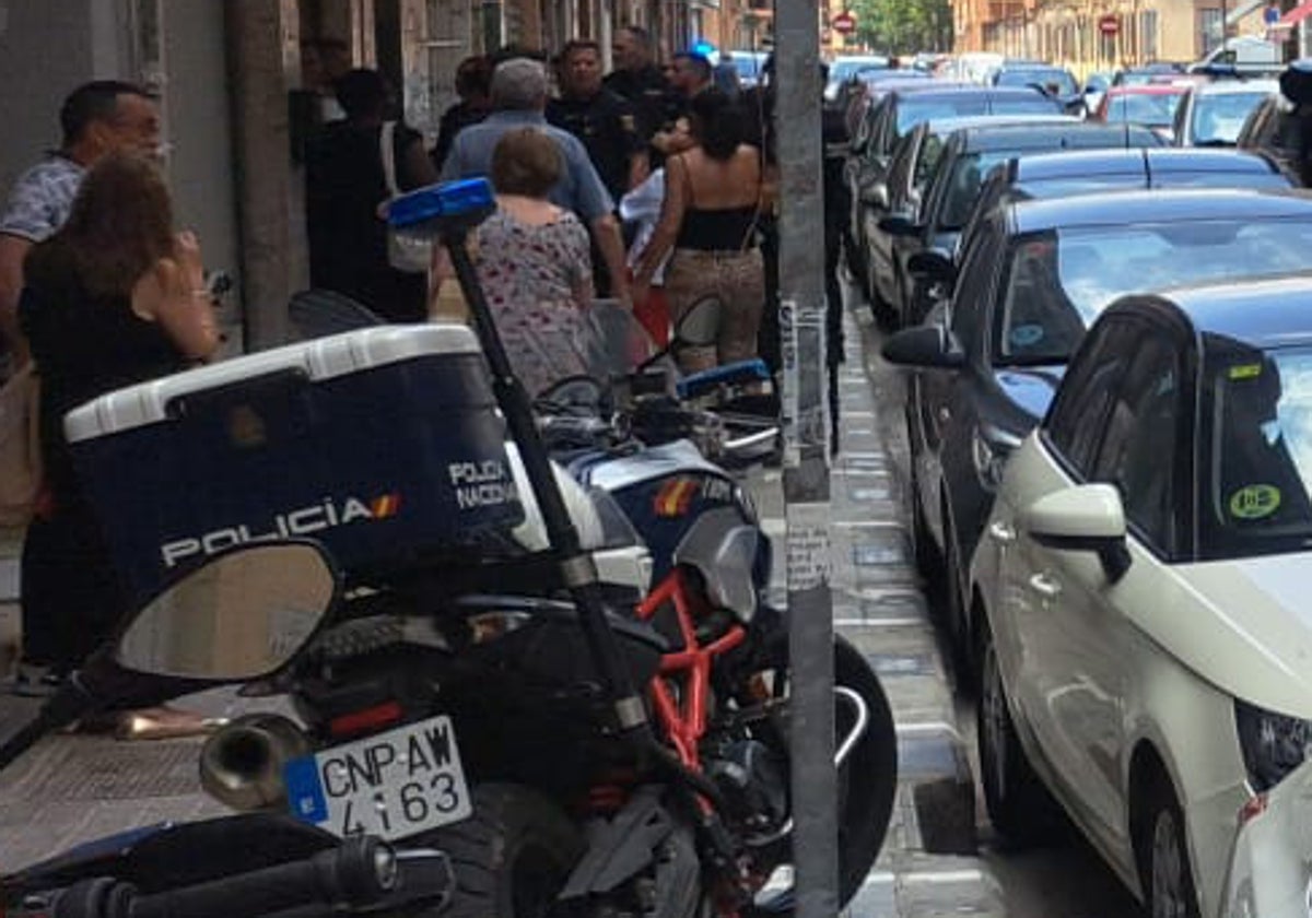 Un grupo de vecinos y policías comentan el suceso en la calle.