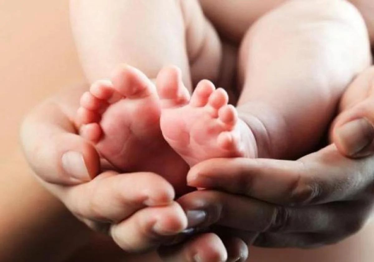 Pies de un bebé sobre unas manos