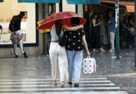 Dos mujeres pasean por la calle en Valencia, hoy.