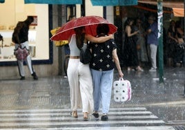 Dos mujeres pasean por la calle en Valencia, hoy.
