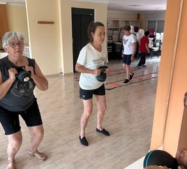 Varias personas mayores realizando ejercicias de pesas.