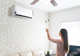 Una mujer ajusta la temperatura del aire acondicionado.