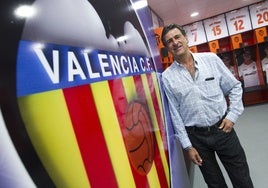 Mario Alberto Kempes posa junto al escudo del Valencia CF.